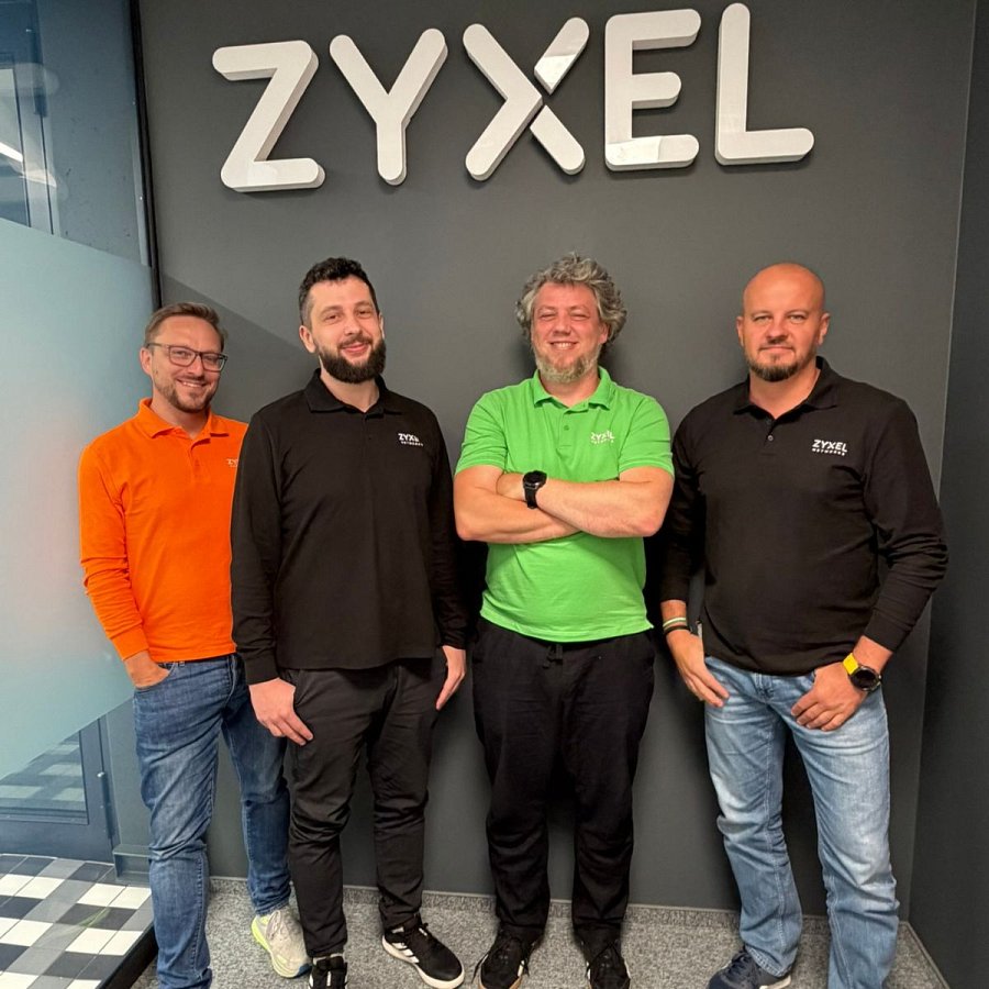 4-osobowy zespół Zyxel Networks Polska na tle ścianki z logo Zyxel